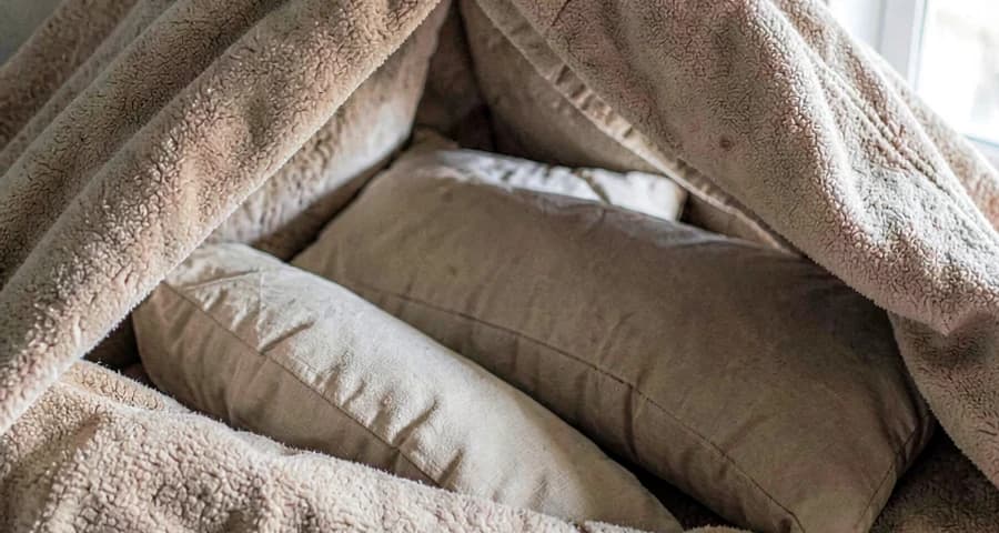 cabana de cobertores e almofadas montada em atividade sensorial na creche