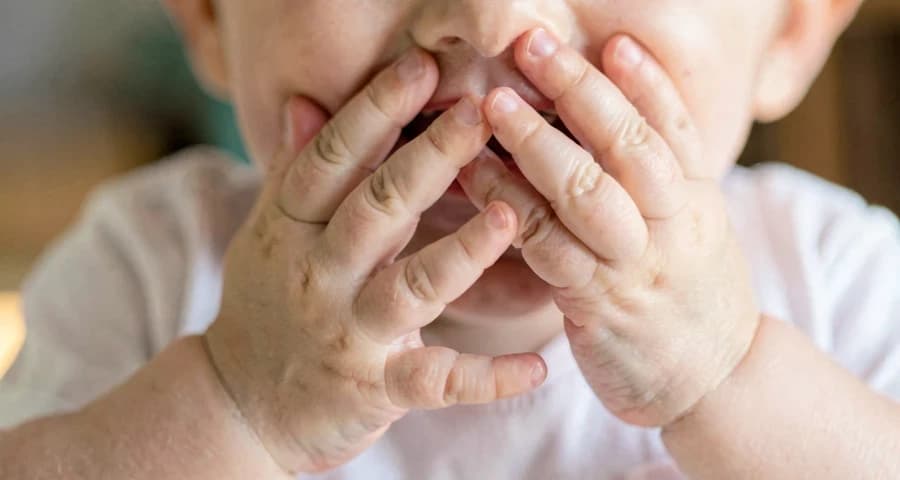 bebê cobrindo o próprio rosto durante brincadeira interativa na creche