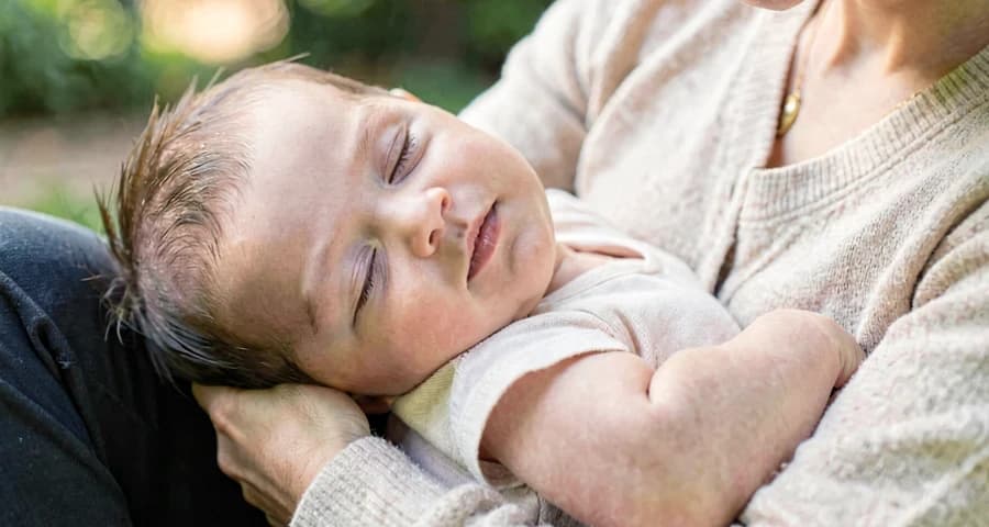 bebê relaxado no colo durante atividade de canção de ninar na creche